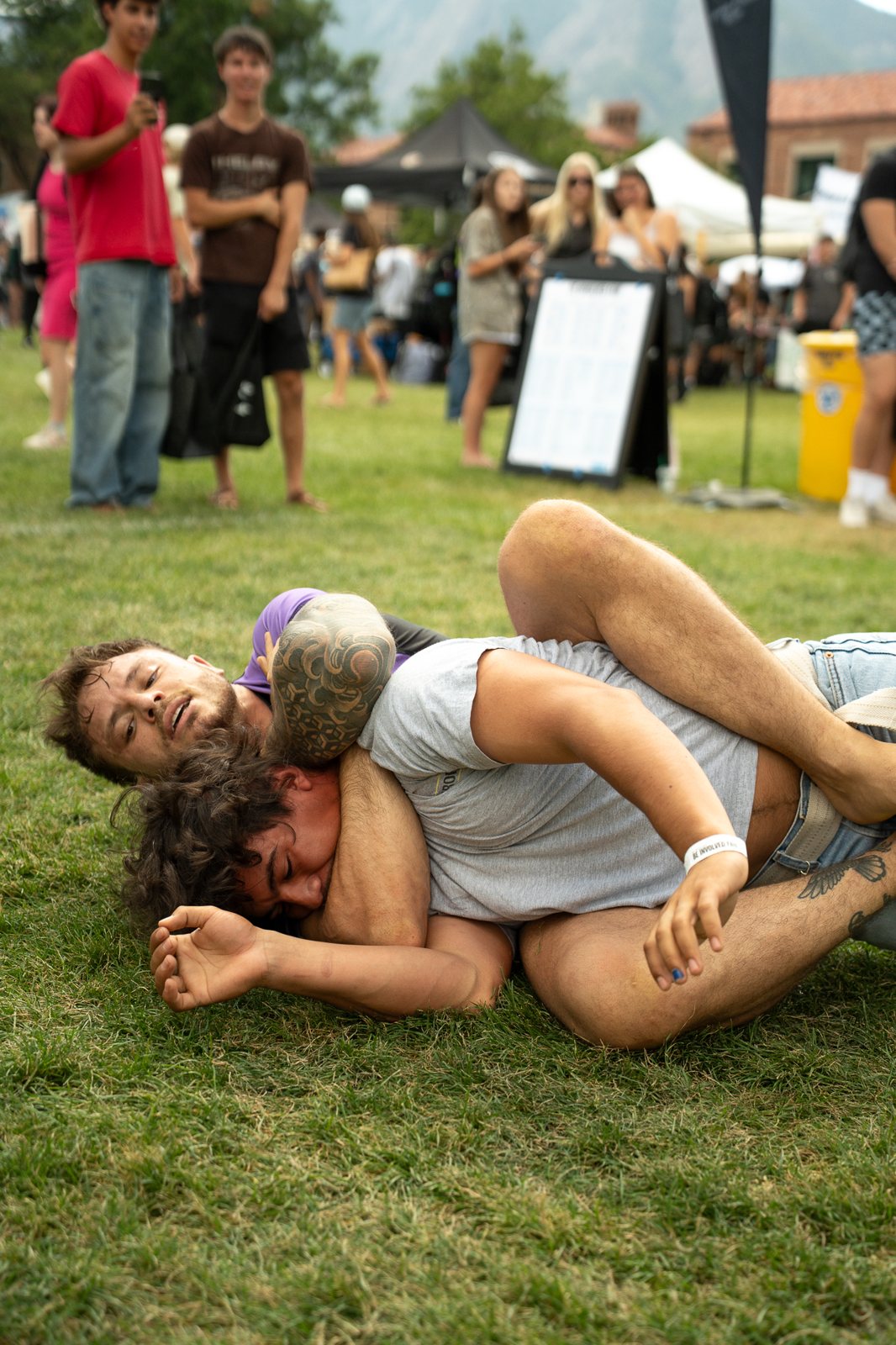 Grapplers competing on grass at an outdoor event
