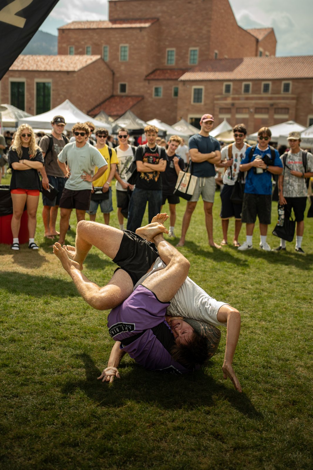 Grapplers competing outdoors with a crowd watching